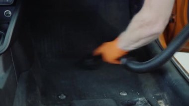 Adam araba iç elektrikli süpürge ile temizler