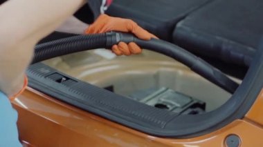Adam araba iç elektrikli süpürge ile temizler