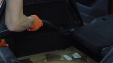 Adam araba iç elektrikli süpürge ile temizler