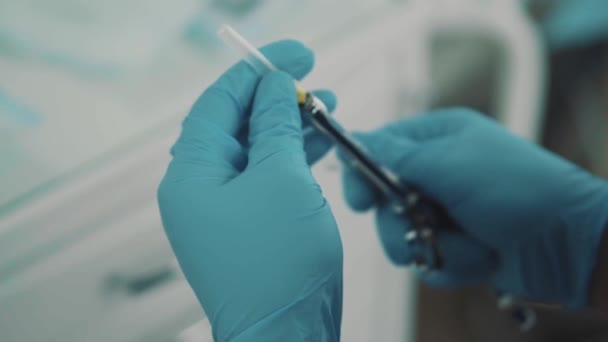 Стоматолог вынимает шприц и вставляет в него ампулу. . — стоковое видео