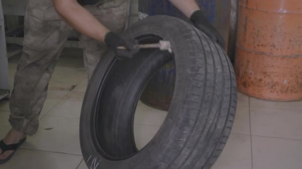 Мужчина снимает резину с колеса автомобиля — стоковое видео