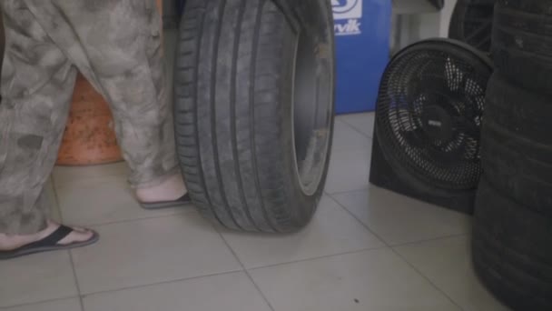 Man removes rubber from the car wheel — Stock Video
