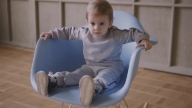 Kız ikizler birlikte evde çalışan bir sandalyenin üstüne oyun oynamak