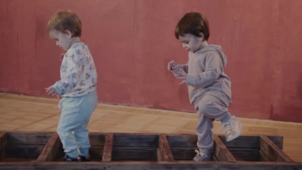 Сестри близнюки грають разом бігаючи по будинку і піднімаючись по сходах — стокове відео