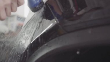 bir adam bir koruyucu tabaka uygulamadan önce arabanın ön yıkar,