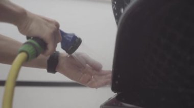 bir adam bir koruyucu tabaka uygulamadan önce arabanın ön yıkar