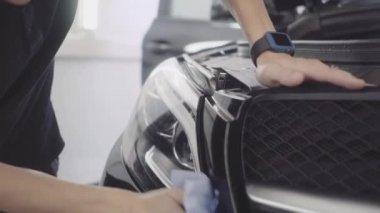 bir adam bir koruyucu tabaka uygulamadan önce arabanın ön yıkar