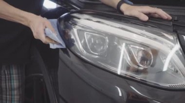 bir adam bir koruyucu tabaka uygulamadan önce arabanın ön yıkar