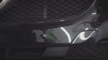 bir adam bir koruyucu tabaka uygulamadan önce arabanın ön yıkar