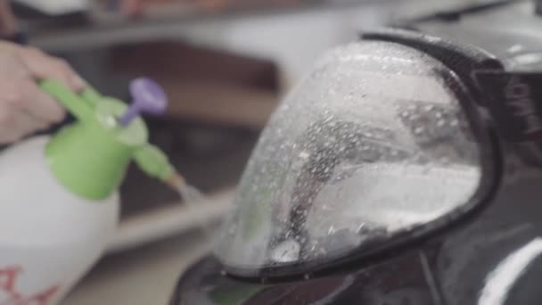 Seorang pria mencuci bagian depan mobil sebelum menerapkan lapisan pelindung di atasnya — Stok Video