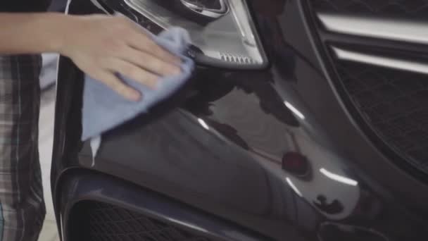 A man washes the front of the car before applying a protective layer on it — Stock Video