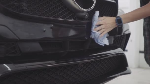 Człowiek myje przód samochodu przed nałożeniem warstwy ochronnej na nim — Wideo stockowe