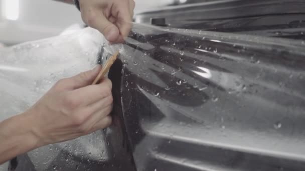 Мастер наносит защитный слой на поверхность автомобиля — стоковое видео