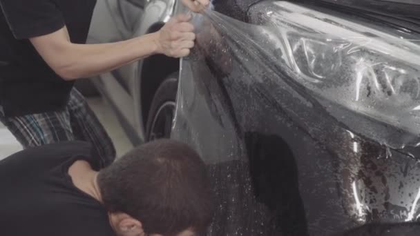 Майстер наносить захисний шар на поверхню автомобіля — стокове відео