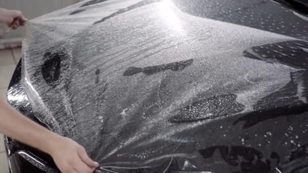 Мастер наносит защитный слой на поверхность автомобиля — стоковое видео