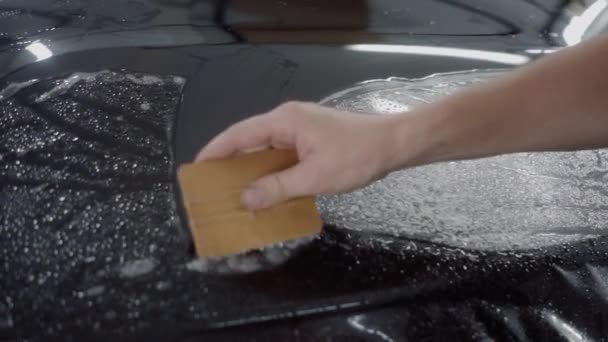 Le capitaine applique une couche protectrice sur la surface de la voiture — Video