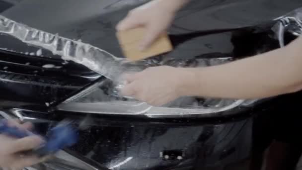 Le capitaine applique une couche protectrice sur la surface de la voiture — Video