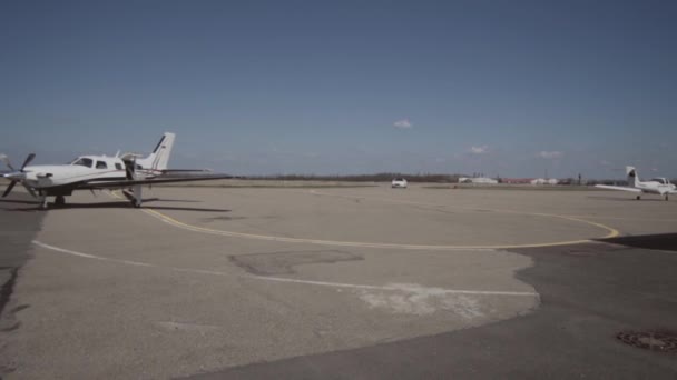 Мужчина выходит из частного самолета и идет к машине — стоковое видео