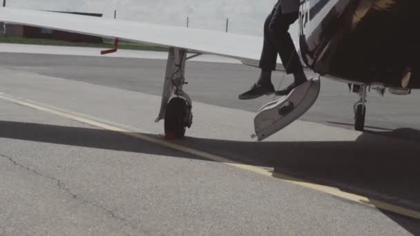 Mężczyzna opuszcza prywatny samolot i idzie do samochodu — Wideo stockowe
