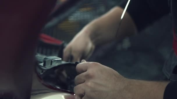 Auto mechanik nainstaluje ochranné pletivo — Stock video