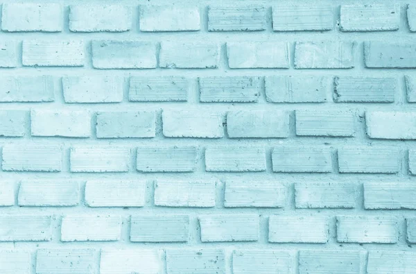 Brick wall painted with pale blue paint pastel calm tone texture background. Brickwork and stonework flooring interior rock old pattern clean concrete grid uneven bricks design stack.