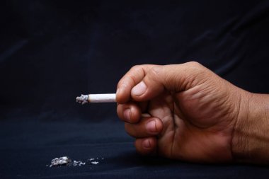 Kişi El koyu siyah arka plan üzerinde bir sigara kırma için. Qui