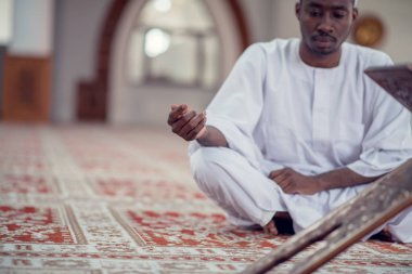 Siyah Afrika Müslüman adam olduğunu dua içinde Camii Kur'an açık kutsal kitap ile