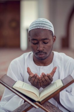 Siyah Afrika Müslüman adam olduğunu dua içinde Camii Kur'an açık kutsal kitap ile