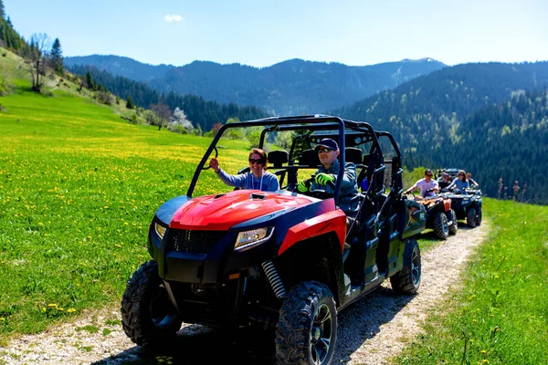 Um grupo de turismo viaja em ATVs e UTVs nas montanhas — Fotografia de Stock