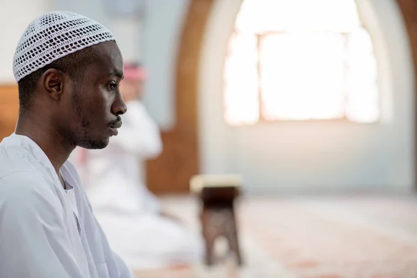 Afrikanischer muslimischer Mann, der traditionelles Gebet zu Gott spricht, während er Dischdascha trägt — Stockfoto