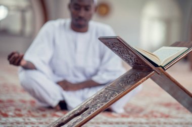 Siyah Afrika Müslüman adam olduğunu dua içinde Camii Kur'an açık kutsal kitap ile
