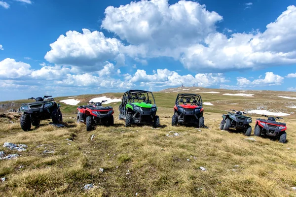 Park edilmiş Atv ve Utv, arabaları ile arka planda mavi gökyüzü ve bulutlar dağ tepe üzerinde