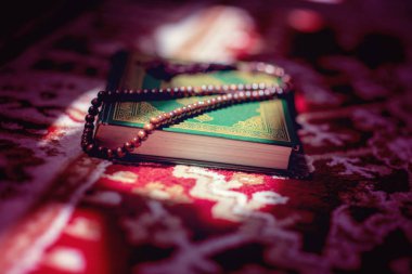 prayer beads on Koran holy book of Muslims clipart