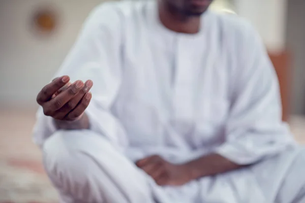 Negro africano muçulmano homem está orando na mesquita com aberto santo livro do Alcorão — Fotografia de Stock