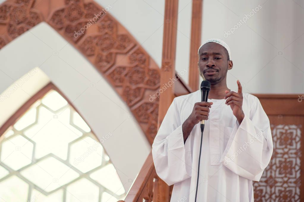 Muslims black african Imam has a speech on friday afternoon prayer in a mosque