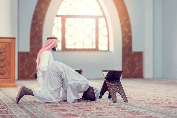 Två religiösa muslimska man ber tillsammans inne i moskén — Stockfoto