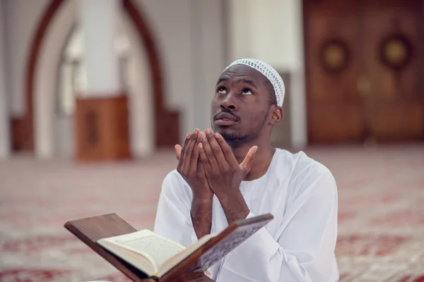 Siyah Afrika Müslüman adam olduğunu dua içinde Camii Kur'an açık kutsal kitap ile — Stok fotoğraf