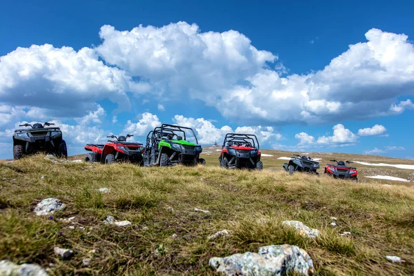 Estacionamento ATV e UTV, buggies no pico da montanha com nuvens e céu azul no fundo — Fotografia de Stock