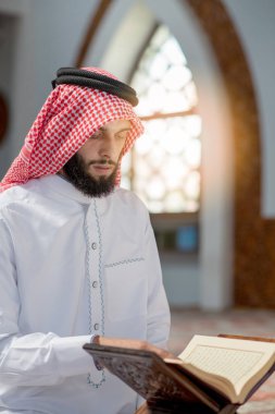 Dindar Müslüman adam caminin içinde dua ediyor.