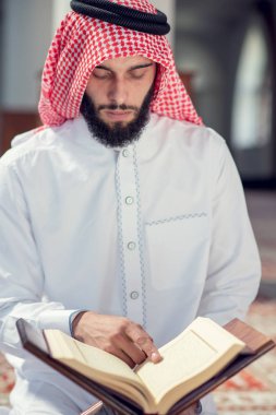 Dindar Müslüman adam caminin içinde dua ediyor.