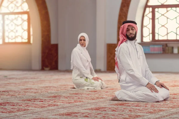 Muçulmano homem e mulher orando por Deus na mesquita juntos — Fotografia de Stock