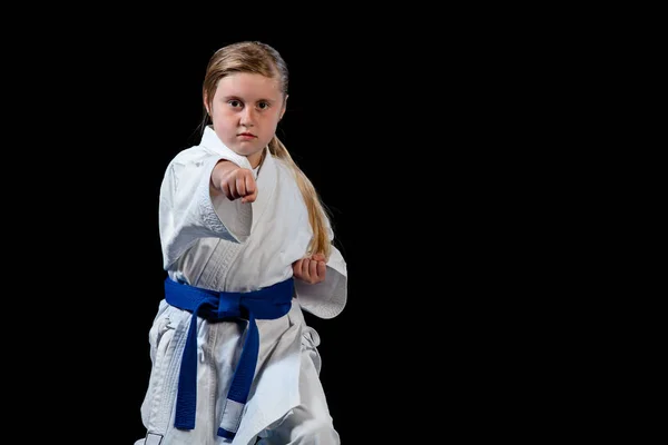 Lief klein meisje in de praktijk van vechtsporten zoals karate kid alleen geïsoleerd op zwarte achtergrond — Stockfoto