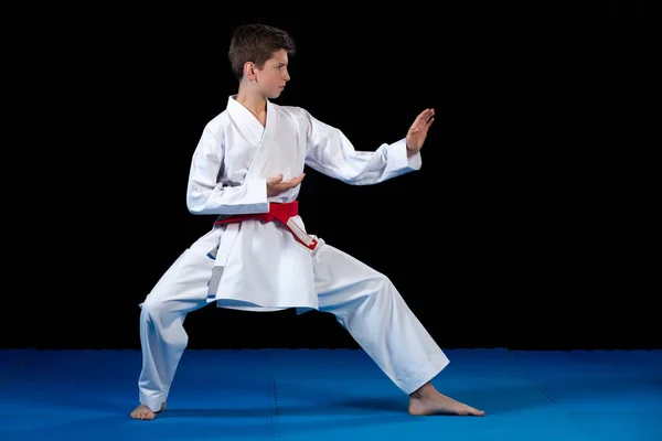 Kırmızı kemer ile bir beyaz karate kimono giymiş genç çocuk. — Stok fotoğraf