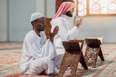 İki dindar Müslüman camide birlikte dua ediyor.