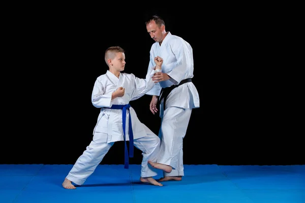 Instructor de karate masculino entrenando a niños pequeños en dojo — Foto de Stock