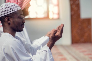 İki dindar Müslüman camide birlikte dua ediyor.