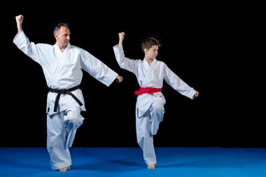 Male karate instructor training little children in dojo clipart