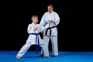 Male karate instructor training little children in dojo clipart