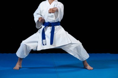 Pre-Teen Çocuk siyah bir zemin üzerine karate yapıyor