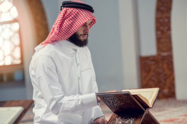 Dindar Müslüman adam caminin içinde dua ediyor.